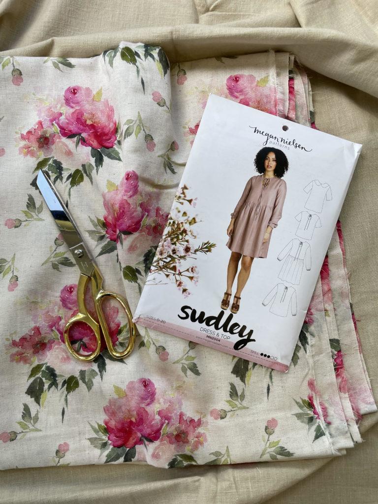 Sudley Dress Pattern package, uncut pink flowered fabric & scissors