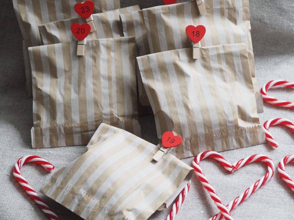 Little paper bags holding mini yarn skeins with candy canes nearby