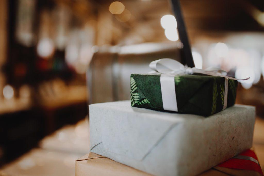 A white gifted wrapped box with a dark green box on top