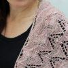 Delicate fine knit pink shawl with green stripe.