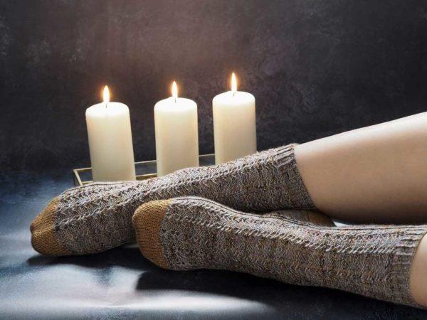 The ambient socks are light brown and mustard yellow toes and heels. theres a candle burning near by adding to a warm cosy feeling.