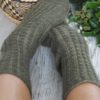 The Curling Mist Socks are a moss green knit, from the top-down with tiny cables and continue all over the leg and onto the top of the foot.