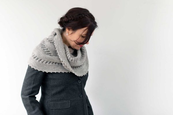 The Hill Top Shawl with arched edges and a beautiful details throughout in a soft grey colour.