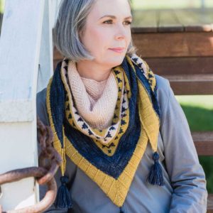 The Hinterlands Shawl is a generous triangle shawl, knit in three colours - blue, yellow and cream.