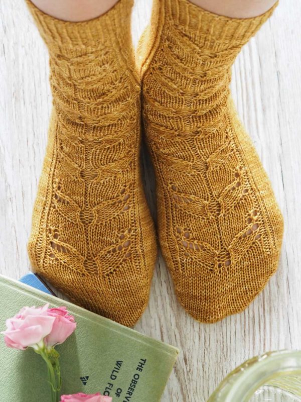 The Wild Bees Socks pattern features three sizes, a bee-inspired lace panel travels down the front of the leg and the top of the sock, ending with a pretty eye of partridge heel and a round toe.
