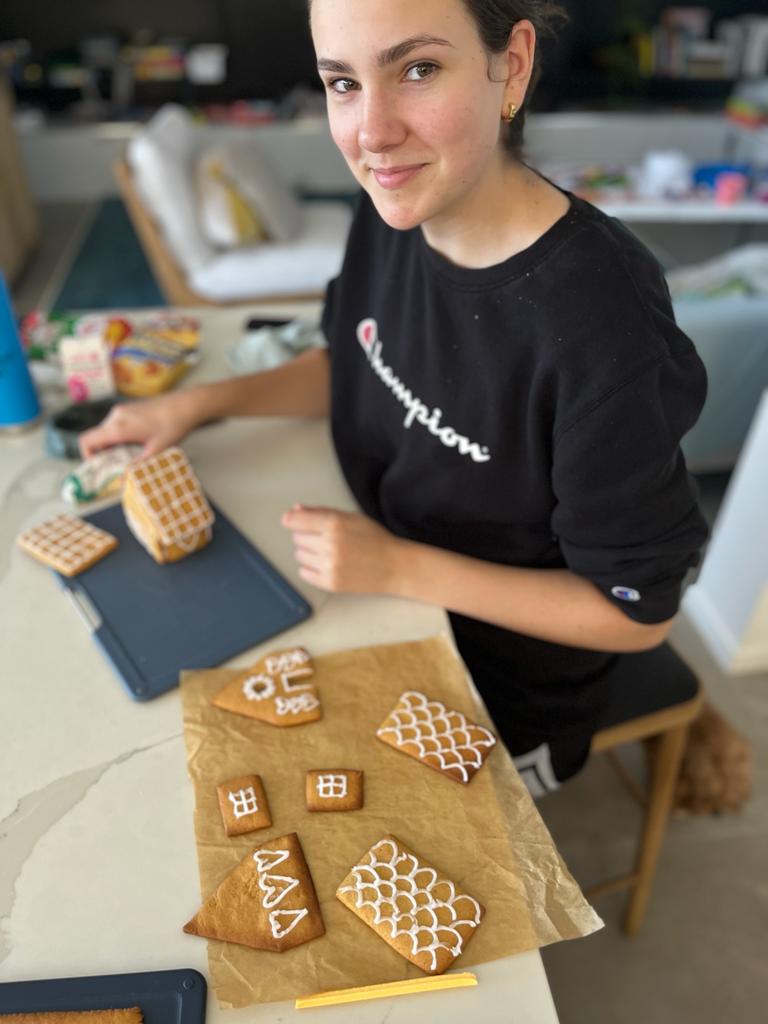 Helen's daughter Sophie smiles at the camera while working on gingerbread houses.