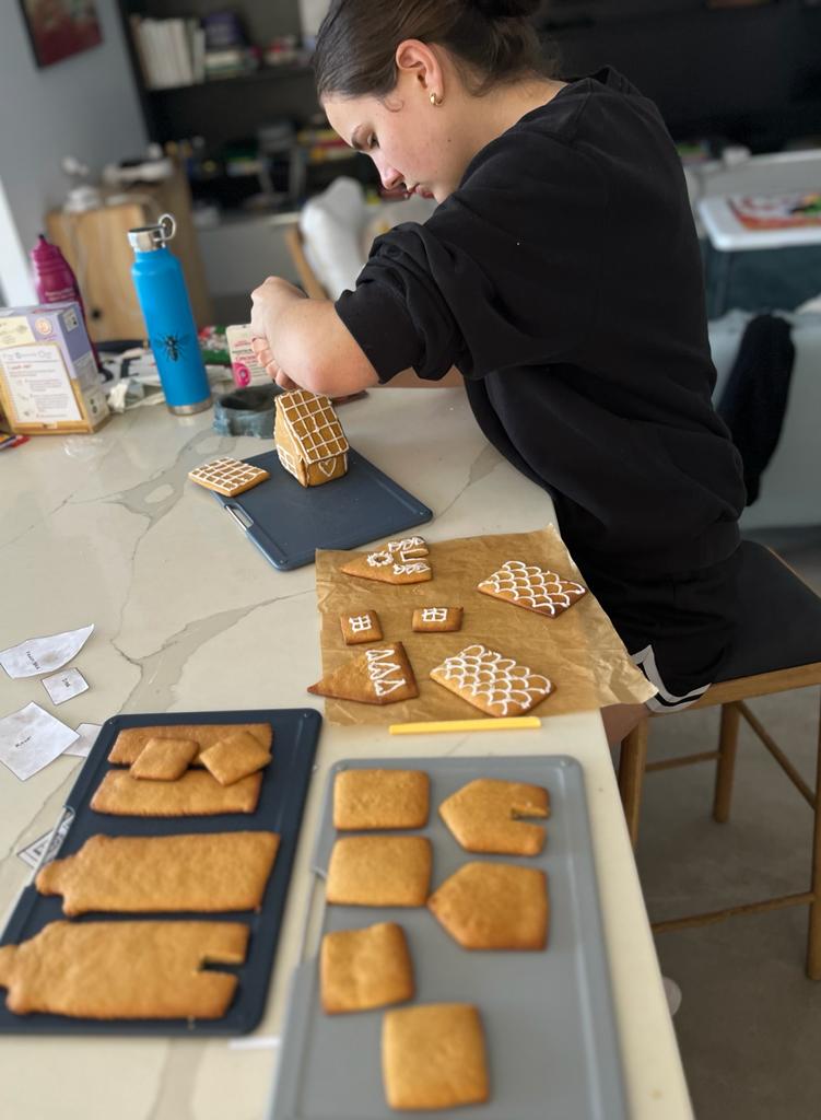 Helen's daughter Sophie concentrating on decorating a gingerbread house with icing. 
