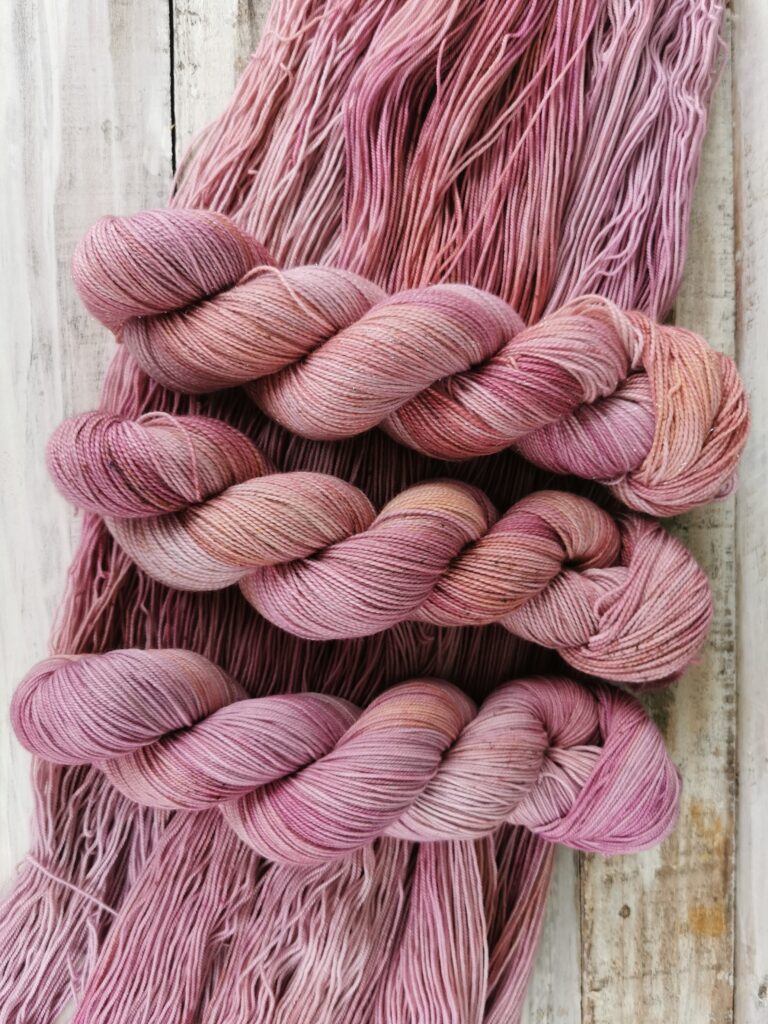 Three skeins of pink sock yarn